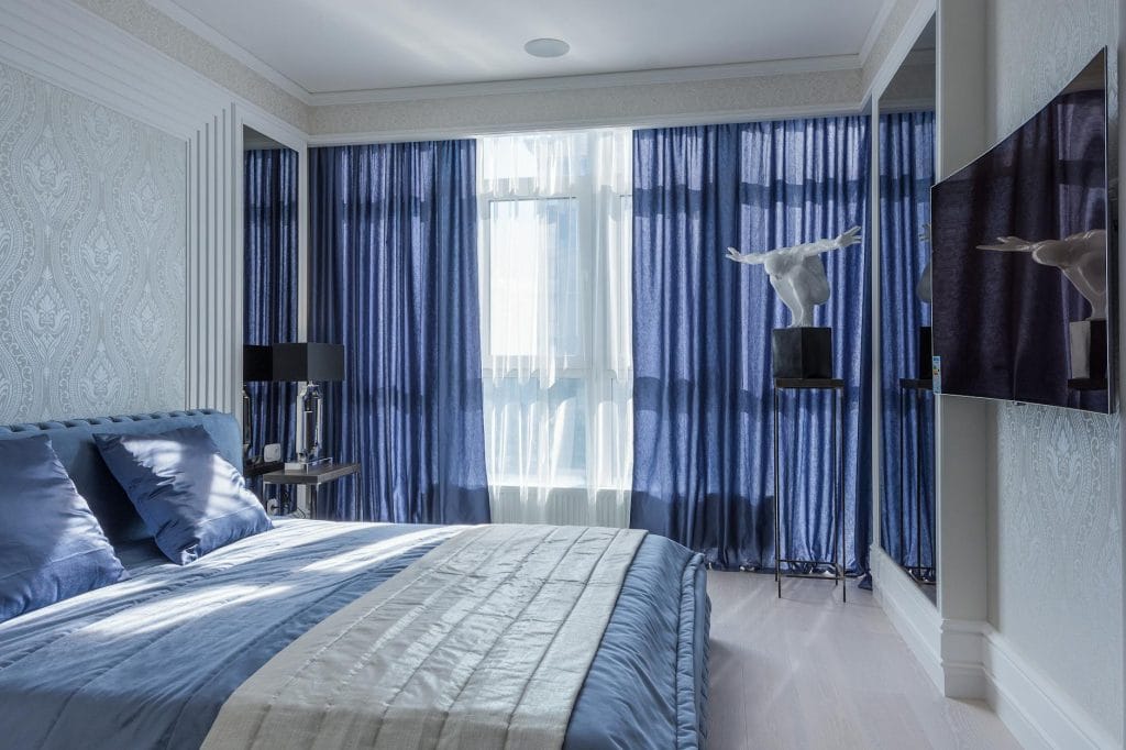 interior of bedroom with pearl wallpapers and blue curtains